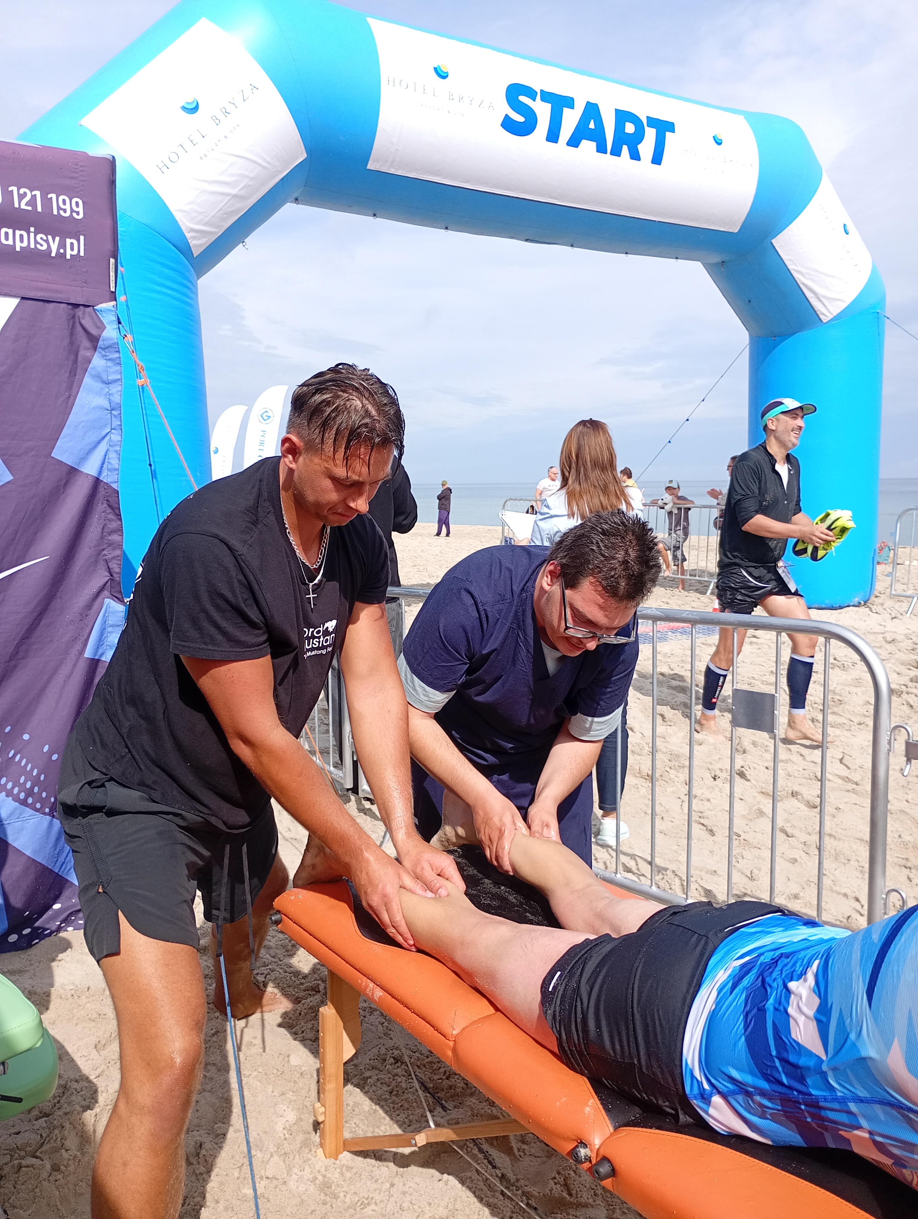Zdjęcie masażu uczestników biegu na plaży.
